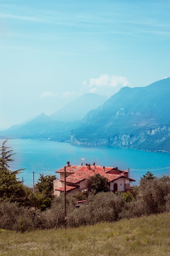Picturesque view of a house overlooking Lake Garda near Malcesine with mountains in the background.
